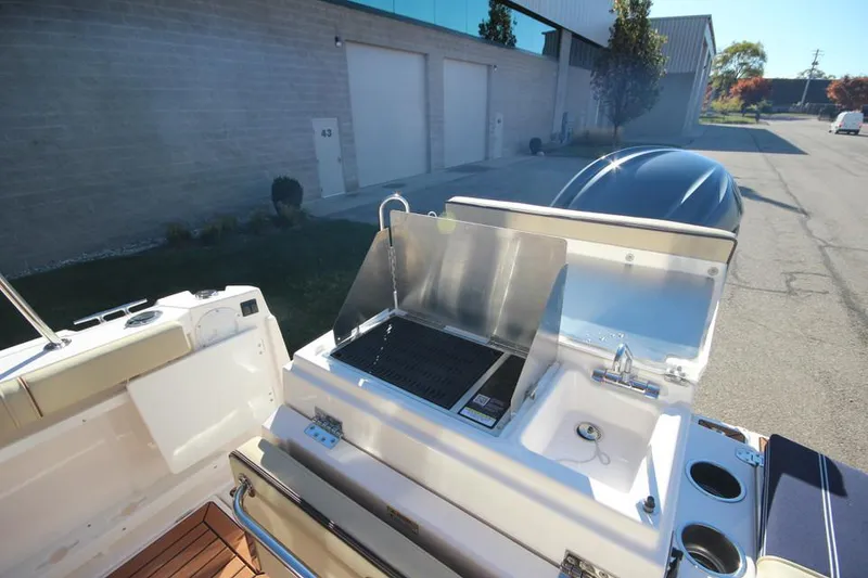 Slide: The Image of 2026 Ranger Tugs R-27 interior kitchen with stove, sink, and compact fridge. - 12