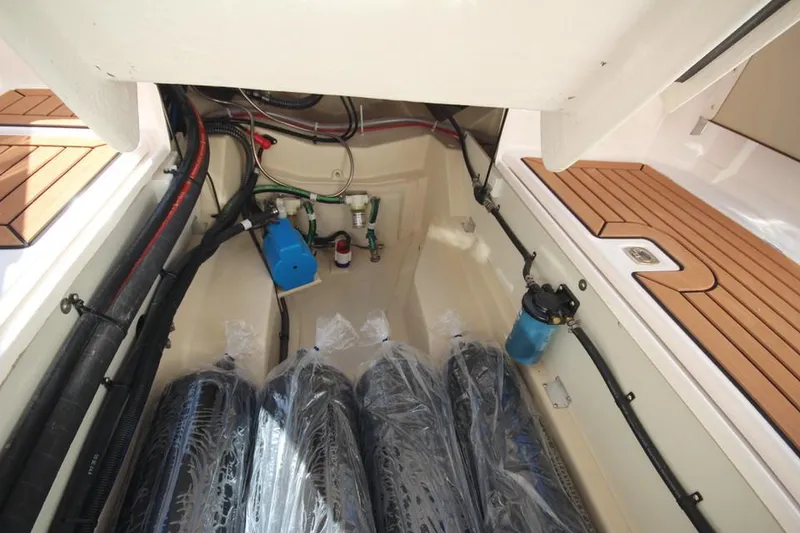 Slide: The Image of Interior of 2026 Ranger Tugs R-27 with wooden table and white seating. - 16