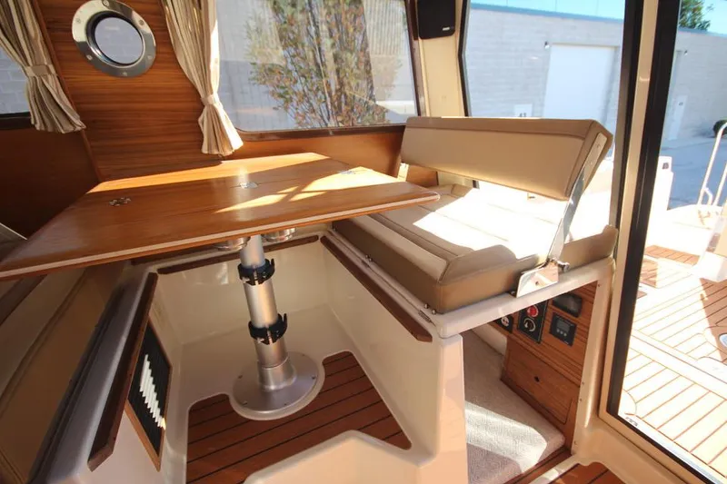 Slide: The Image of 2026 Ranger Tugs R-27 interior cabin with wood paneling and modern amenities. - 24