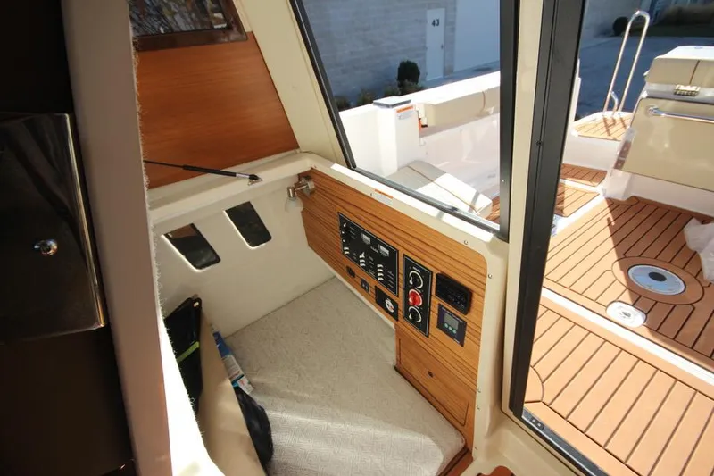 Slide: The Image of 2026 Ranger Tugs R-27 interior cabin with cushioned seating and soft lighting. - 25