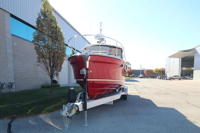 Slide: The Image of 2026 Ranger Tugs R-27 boat interior with seating and kitchenette, showcased at a boat show. - 3