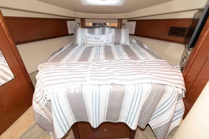 Slide: The Image of Cozy cabin interior of 2007 Sea Ray 40 Sundancer with striped bedding and nautical decor. - 14