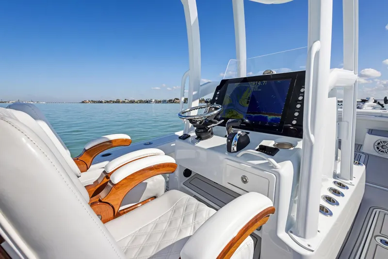 Slide: The Image of 2022 Barker Boatworks 26 Open helm with modern controls and luxurious seating on calm waters. - 22