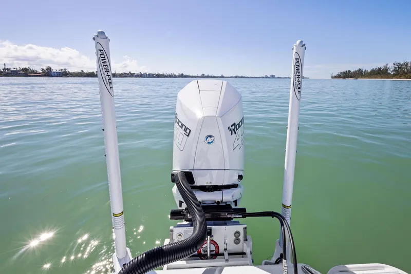 Slide: The Image of 2022 Barker Boatworks 26 Open on calm water, featuring dual power poles and outboard motor. - 27