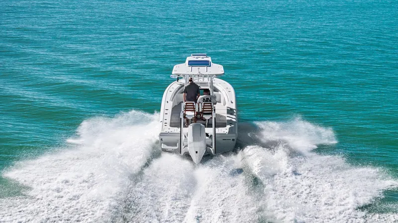 Slide: The Image of 2022 Barker Boatworks 26 Open cruising on clear blue water, rear view. - 32