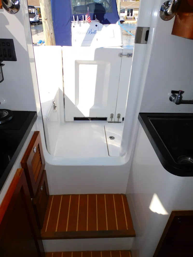 Slide: The Image of Interior view of a 2022 SeaPiper 35 with wooden flooring and access to the exterior door. - 25