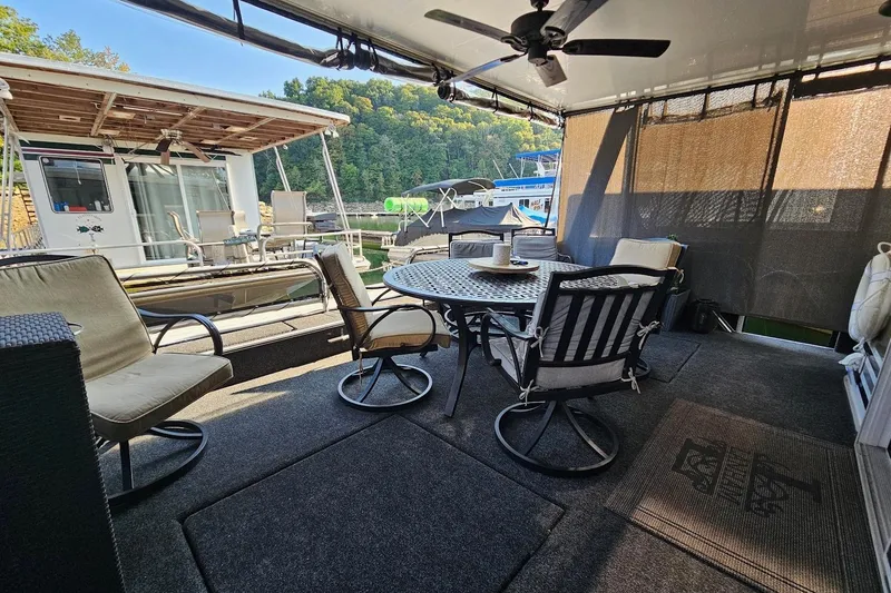 Slide: The Image of Outdoor seating area on a 2000 Sumerset 16x75 houseboat with patio furniture and ceiling fan. - 2
