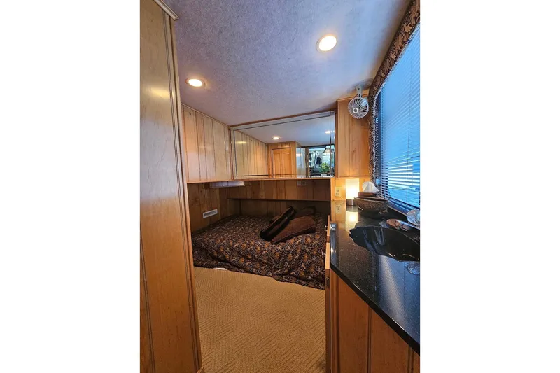 Slide: The Image of Cozy bedroom interior of 2000 Sumerset 16x75 houseboat with wood paneling and soft lighting. - 20