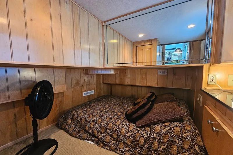 Slide: The Image of Cozy bedroom in 2000 Sumerset 16x75 houseboat with wood paneling and patterned bedding. - 21