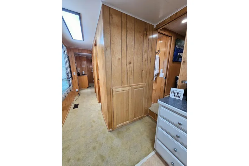 Slide: The Image of Interior of 2000 Sumerset 16x75 houseboat with wood paneling and carpeted hallway. - 26