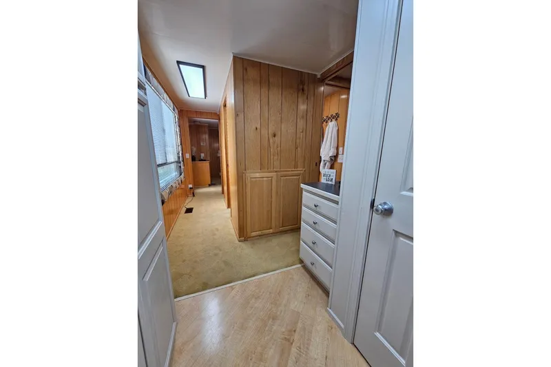 Slide: The Image of Interior hallway of 2000 Sumerset 16x75 houseboat with wood paneling and cabinetry. - 27