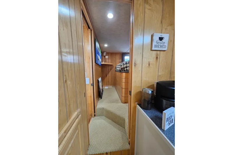 Slide: The Image of Interior of 2000 Sumerset 16x75 houseboat with wood paneling and cozy decor. - 28