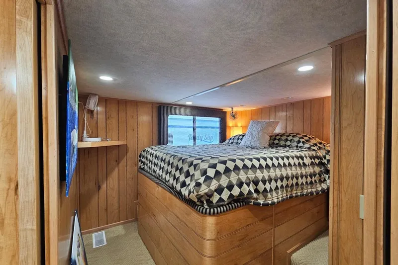 Slide: The Image of Cozy bedroom in 2000 Sumerset 16x75 houseboat with wood paneling and geometric bedding. - 29