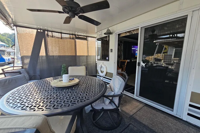 Slide: The Image of Outdoor seating area on a 2000 Sumerset 16x75 houseboat with table and chairs. - 3