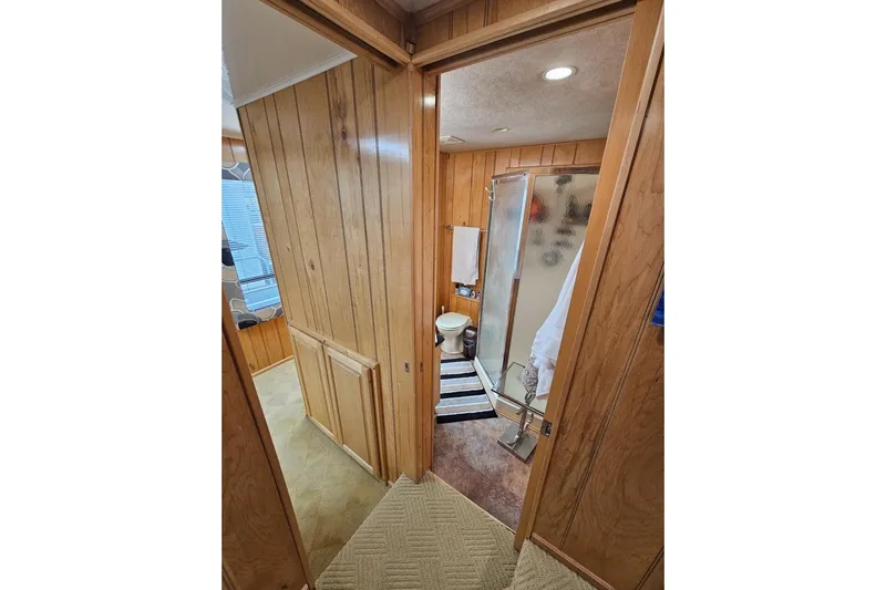 Slide: The Image of Bathroom interior of 2000 Sumerset 16x75 houseboat with wood paneling and shower. - 30