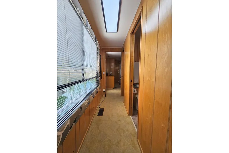 Slide: The Image of Interior hallway of 2000 Sumerset 16x75 houseboat with wood paneling and large windows. - 34