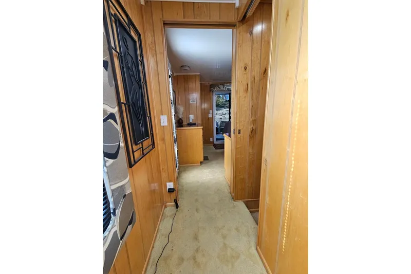 Slide: The Image of Narrow hallway in a 2000 Sumerset 16x75 houseboat with wood paneling and carpet. - 35