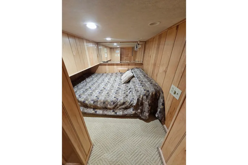 Slide: The Image of Cozy bedroom in 2000 Sumerset 16x75 houseboat with wood paneling and patterned bedding. - 38