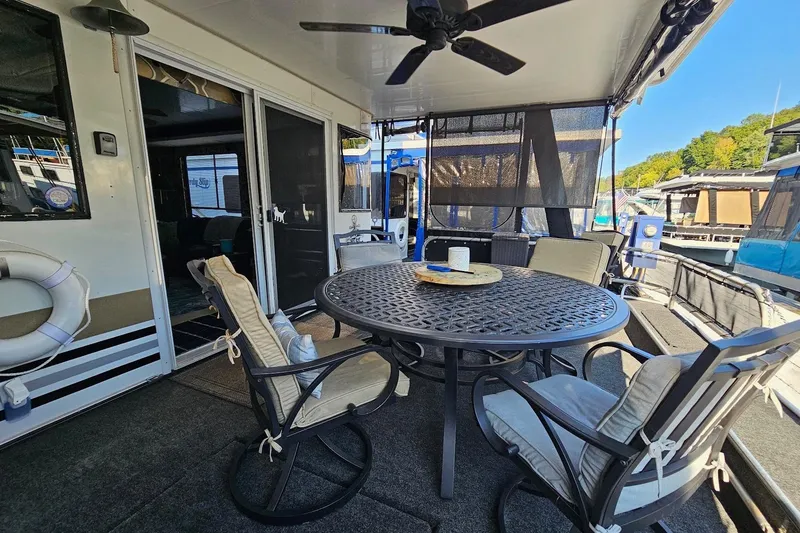 Slide: The Image of Outdoor seating area on a 2000 Sumerset 16x75 houseboat with table and chairs. - 4