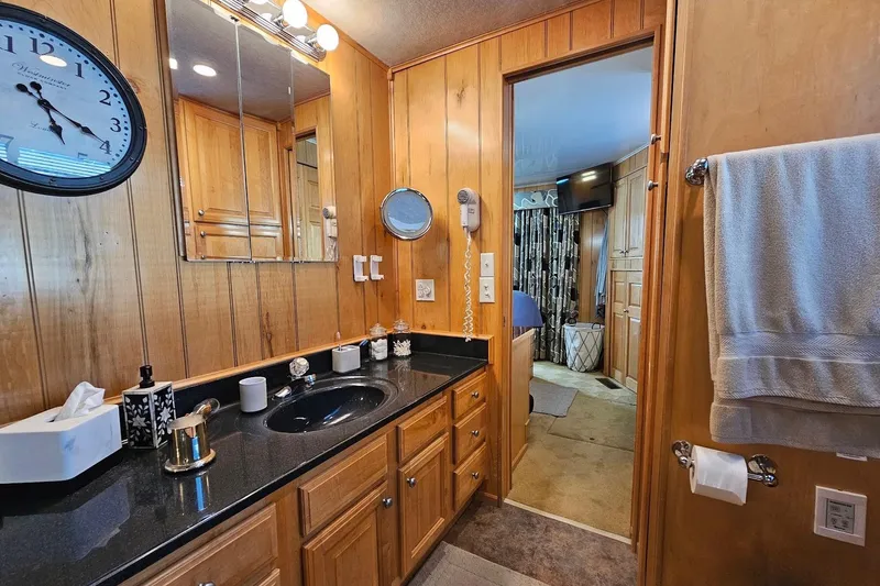 Slide: The Image of Luxurious bathroom in a 2000 Sumerset 16x75 houseboat with wood paneling and modern amenities. - 48