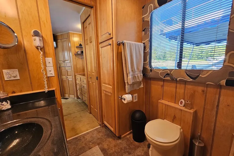 Slide: The Image of Bathroom interior of 2000 Sumerset 16x75 houseboat with wood paneling and modern amenities. - 49