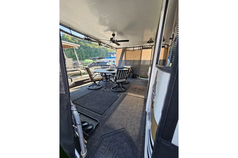 Slide: The Image of Outdoor seating area on a 2000 Sumerset 16x75 houseboat with ceiling fan and table. - 5