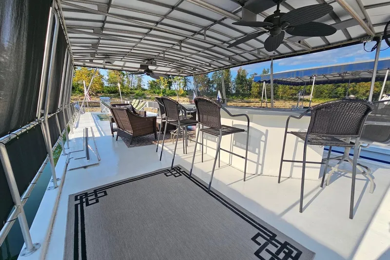 Slide: The Image of Covered deck area on a 2000 Sumerset 16x75 houseboat with seating and ceiling fans. - 56