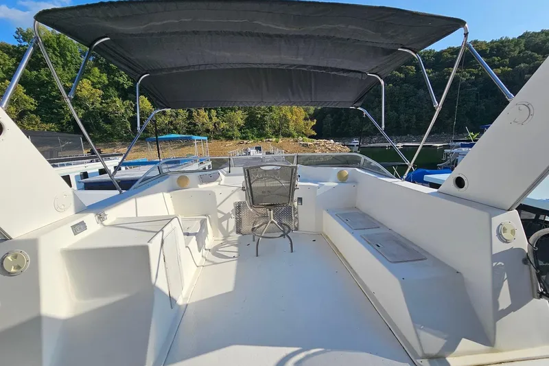 Slide: The Image of 2000 Sumerset 16x75 houseboat deck with canopy, docked near lush greenery. - 58