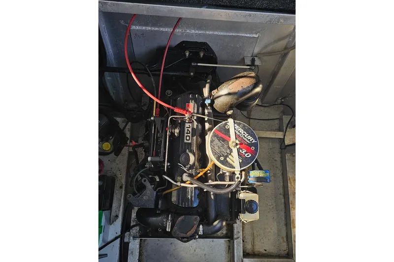 Slide: The Image of Engine compartment of a 2000 Sumerset 16x75 houseboat, featuring a Mercury 140 motor. - 73