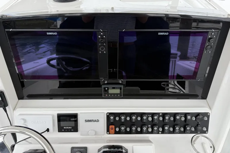 Slide: The Image of Control panel of 2018 Southport 33 FE boat with Simrad displays and switches. - 16