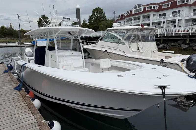 Slide: The Image of 2018 Southport 33 FE boat docked at marina, with white exterior and modern design. - 2
