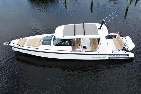 Slide: The Image of 2021 Axopar 37 Sun Top boat on calm water, featuring sleek design and spacious seating. - 4