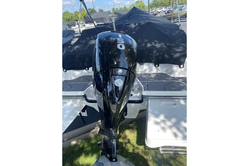 Slide: The Image of 2023 Bayliner DX 2000 boat with a powerful outboard motor, parked outdoors. - 2
