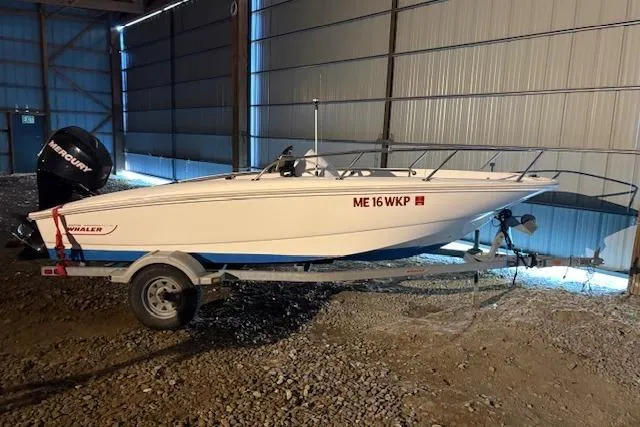 The Image of 2010 Boston Whaler 150 Super Sport boat on trailer in indoor storage. - 0
