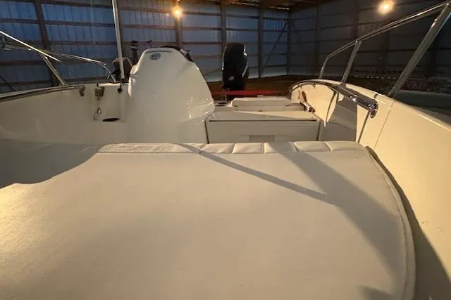 Slide: The Image of 2010 Boston Whaler 150 Super Sport boat interior in a dimly lit storage area. - 8