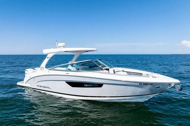Slide: The Image of 2022 Regal 33 OBX boat cruising on open water under clear blue sky. - 1