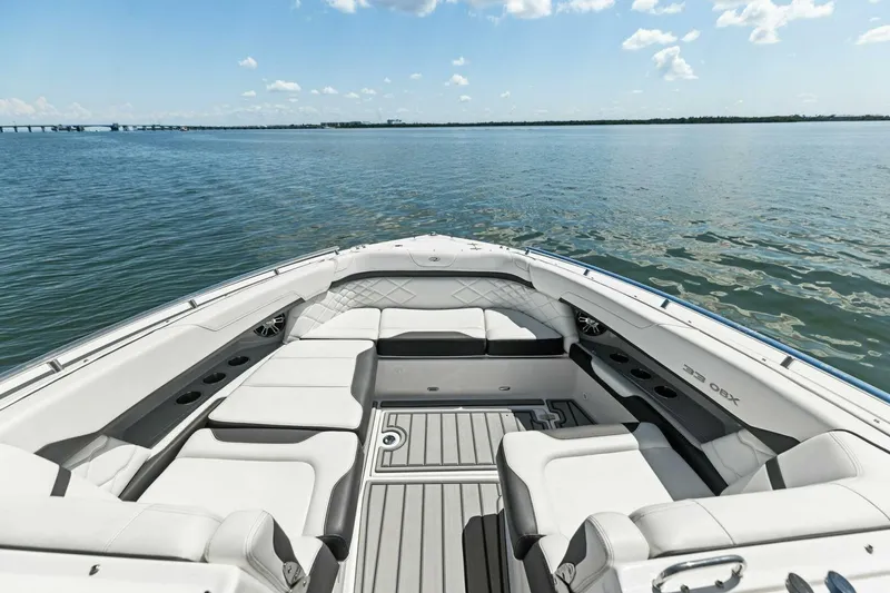 Slide: The Image of 2022 Regal 33 OBX boat interior with luxurious seating on calm water. - 10