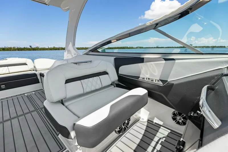 Slide: The Image of 2022 Regal 33 OBX boat interior with sleek seating and modern design on a sunny day. - 24