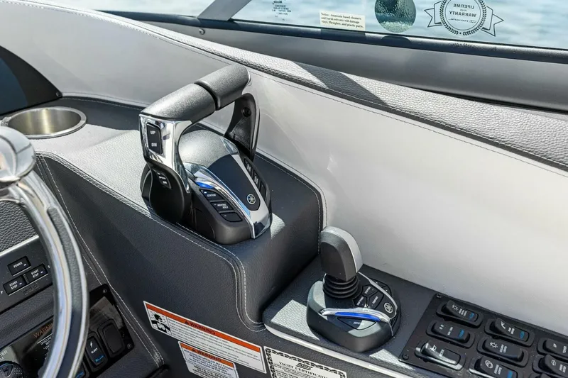 Slide: The Image of 2022 Regal 33 OBX boat controls with steering wheel and throttle levers. - 29