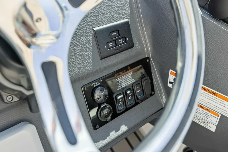 Slide: The Image of 2022 Regal 33 OBX boat dashboard with steering wheel and control switches. - 30