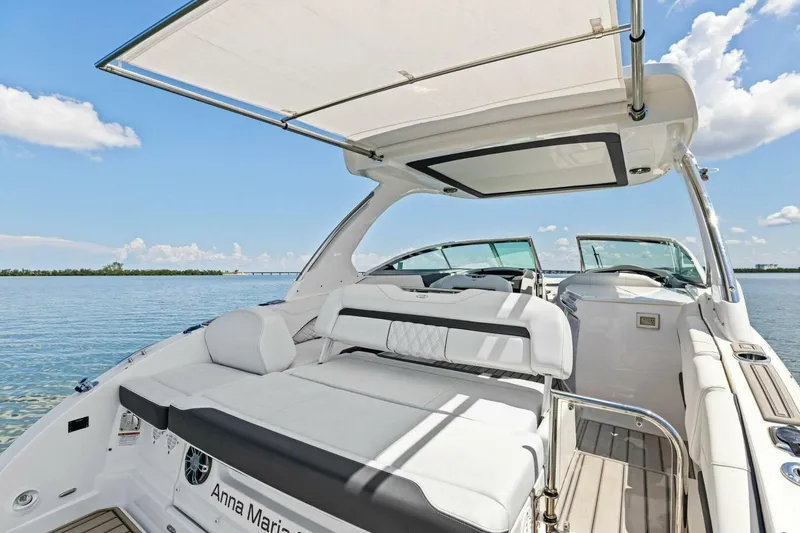 Slide: The Image of 2022 Regal 33 OBX boat interior with spacious seating and canopy on a sunny day. - 4