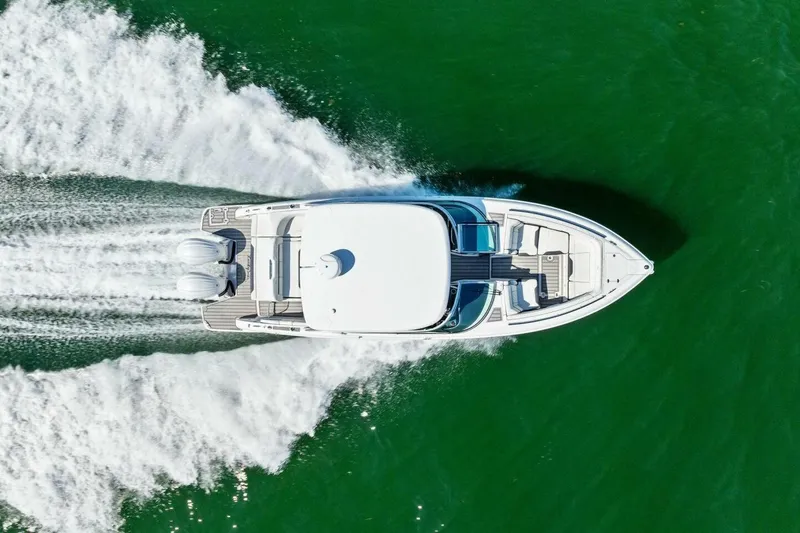 Slide: The Image of Aerial view of 2022 Regal 33 OBX boat cruising on green water. - 50