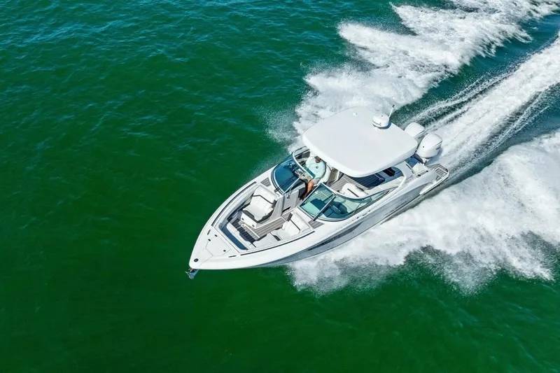 Slide: The Image of 2022 Regal 33 OBX boat cruising on open water, aerial view. - 52