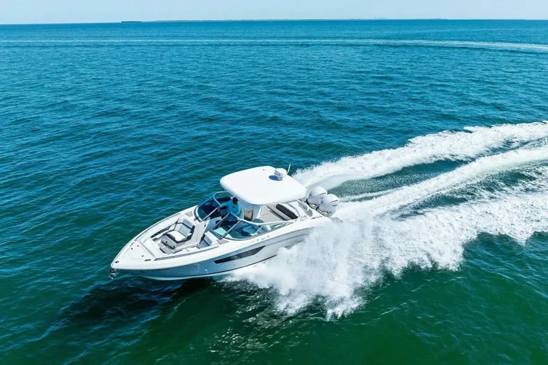 Slide: The Image of 2022 Regal 33 OBX boat cruising on open blue water. - 53