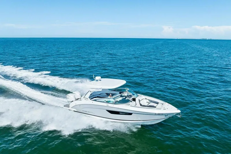 Slide: The Image of 2022 Regal 33 OBX boat cruising on open blue ocean waters. - 55