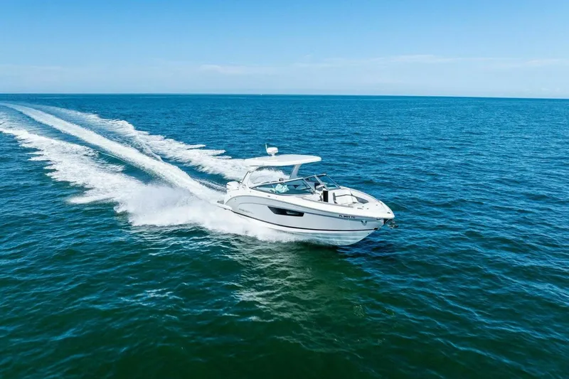 Slide: The Image of 2022 Regal 33 OBX boat cruising on open blue ocean waters. - 56