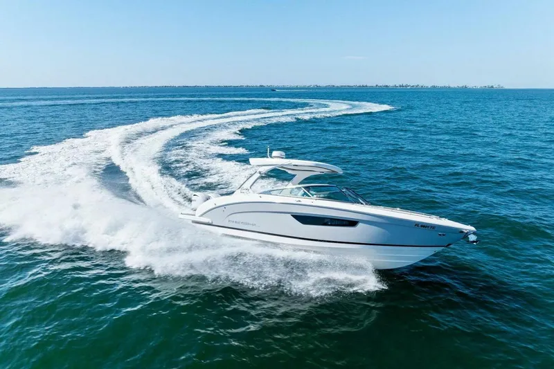 Slide: The Image of 2022 Regal 33 OBX boat cruising swiftly on open blue water. - 58