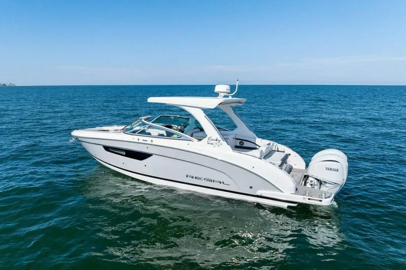 Slide: The Image of 2022 Regal 33 OBX boat cruising on open water with Yamaha engines. - 61