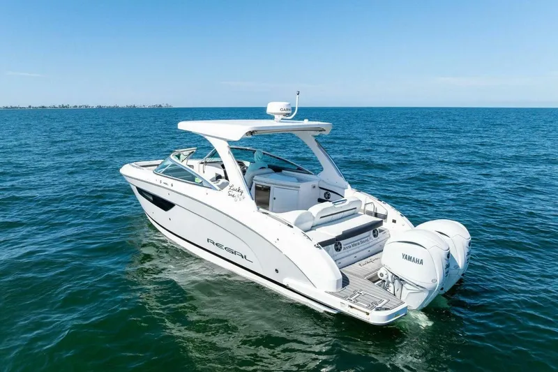 Slide: The Image of 2022 Regal 33 OBX boat cruising on open water with Yamaha engines. - 62