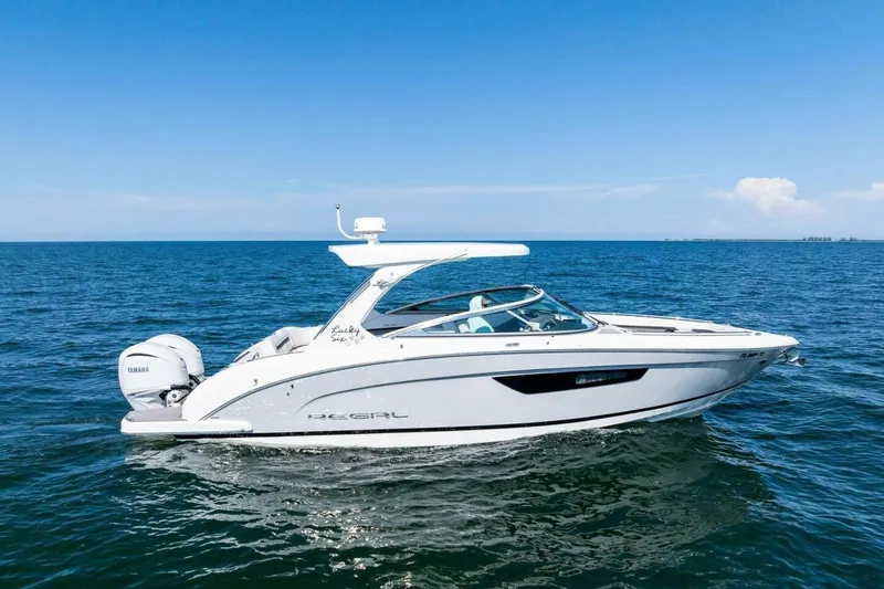 Slide: The Image of 2022 Regal 33 OBX boat cruising on open water under clear blue sky. - 64